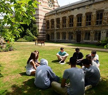 students sat on the grass in a circle, at a college of Oxford University